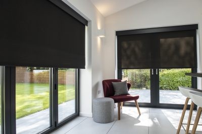 Black roller blinds fitted in a bright conservatory