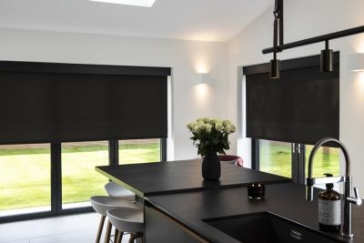 Black roller blinds fitted in a kitchen and dining area