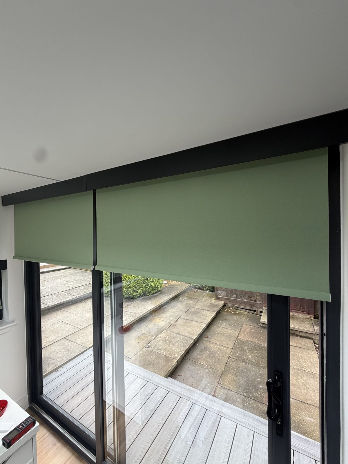 Sage green roller blind fitted to a patio door