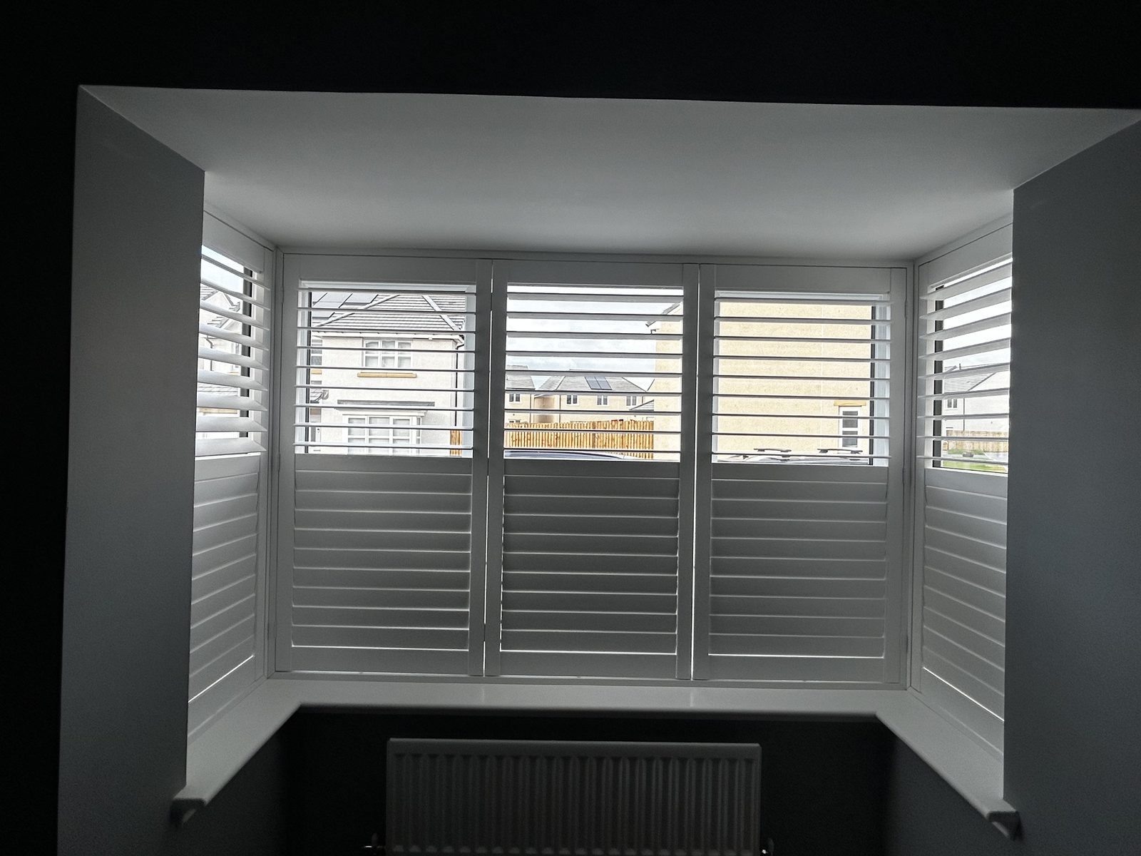Wooden shutters fitted to a bay window in a new build