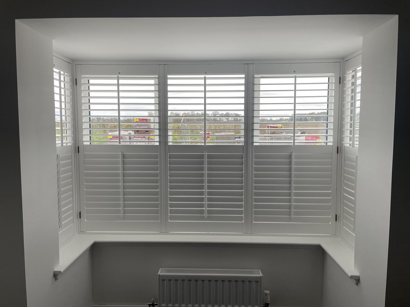 Wooden shutters fitted to a bay window in a new build, Fife